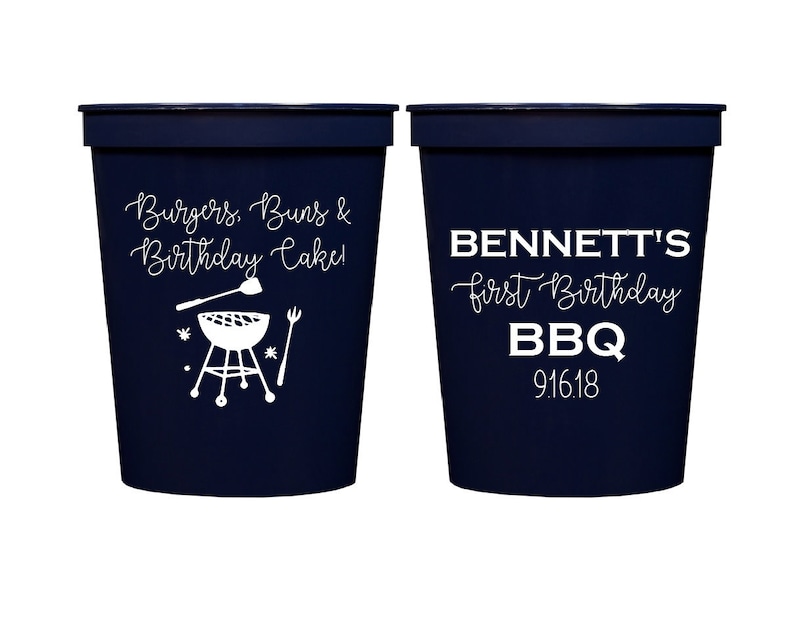 May include: Two blue plastic cups with white text. One cup says "Burgers, Buns & Birthday Cake!" with a grill and spatula graphic. The other cup says "BENNETT'S first Birthday BBQ 9.16.18".