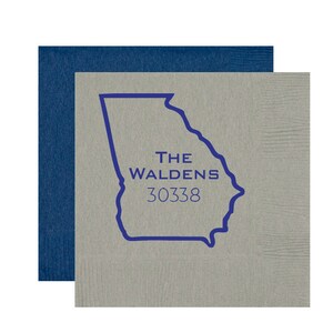 May include: A gray and blue personalized napkin with an outline of the state of Georgia. The text "THE WALDENS 30338" is printed in blue.
