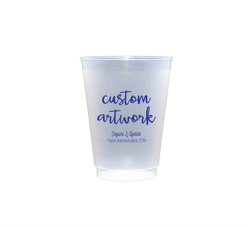 May include: A frosted clear plastic cup with the text "custom artwork" in blue lettering. The text "Sequins & Tradition" and "Paper obsessed since 2014" are also printed in blue lettering.