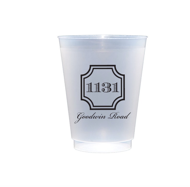 May include: A white plastic cup with a black design. The design features a square with rounded corners and the number "1131" inside. Below the square is the text "Goodwin Road".