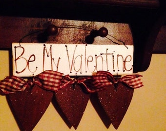 Be my valentine sign with three hearts.