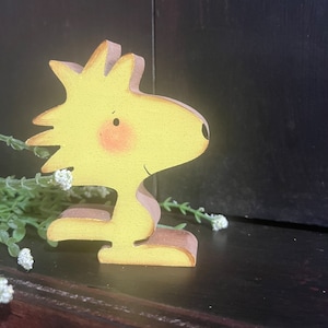 Pájaro de dibujos animados de color amarillo. Estante de madera.