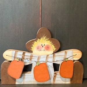 Scarecrow shelf sitter. Holding pumpkins.Pumpkins can be personalized.