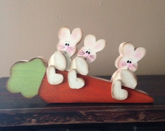 Three bunnies sittin&#39; on a carrot. The bunnies can be personalized.