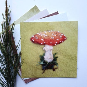Impression de carte postale de champignon vénéneux feutré à l'aiguille orange et rouge.