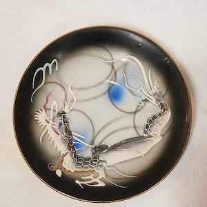 Vintage black dragon ware plate with a blue dragon