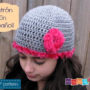 May include: A gray crochet hat with a pink flower and a pink trim. The hat is being worn by a person with long brown hair. The text "Patrón En Español!" is visible in the image. The text "PDF pattern" is also visible in the image.
