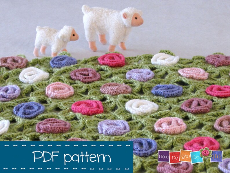 Puede incluir: Un patr&oacute;n de ganchillo para una manta verde con flores de ganchillo de colores. El patr&oacute;n se llama "How Do You Do It?" y est&aacute; disponible para descargar en PDF. Hay dos ovejas de juguete blancas en el fondo.