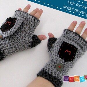 May include: A pair of gray fingerless gloves with a black pocket on each glove. The pockets have a red embroidered letter "M" on them. The gloves are crocheted and have a button on each glove. The text "look for matching knight gloves pattern" is visible in the image.