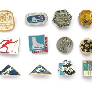 A collection of twelve vintage metal pins featuring various winter sports like skiing, figure skating, and hockey