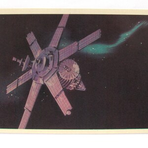 Può includere: Illustrazione di un'astronave nello spazio profondo. L'astronave ha più pannelli solari che si estendono da un mozzo centrale. Una formazione simile a una nebulosa verde e blu è sullo sfondo, con stelle sparse nello spazio buio.