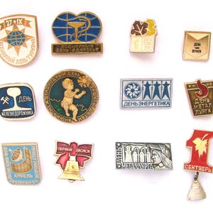 Peut inclure: Une collection de 12 épingles en émail vintage sur divers thèmes, dont un globe, une cloche, un chemin de fer, un soleil, un métallier, un médecin, un enfant, une feuille, un bâtiment et une étoile. Les épingles sont toutes de couleurs et de motifs différents.