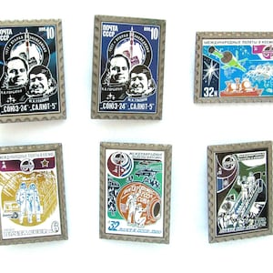 Puede incluir: Colección de seis sellos postales antiguos con temas de exploración espacial. Los sellos muestran imágenes de cosmonautas, cohetes y estaciones espaciales, con texto en cirílico. Cada sello tiene un borde decorativo.