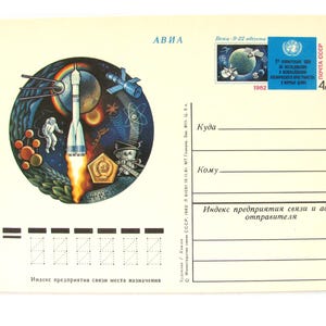 May include: Vintage postcard featuring a colorful illustration of a rocket launching into space, surrounded by planets, satellites, and an astronaut. Includes a postage stamp with a globe and text. The postcard is from 1982.