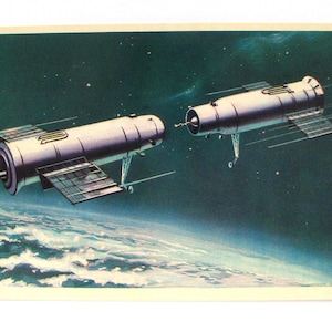Può includere: Una cartolina vintage che raffigura un'illustrazione futuristica di due stazioni spaziali in orbita attorno alla Terra. Le stazioni sono argentate e hanno pannelli solari. Lo sfondo è blu scuro con stelle e una vista dell'atmosfera terrestre.