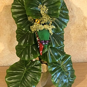 Green plant with butterfly in cardboard pot