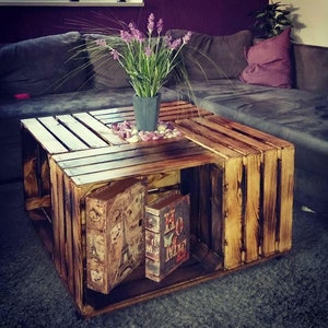 Coffee table made of flamed apple crates on castors