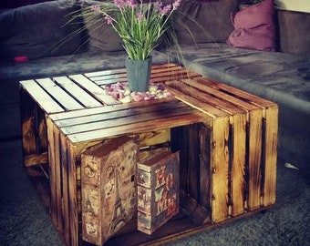 Coffee table made of flamed apple crates on castors