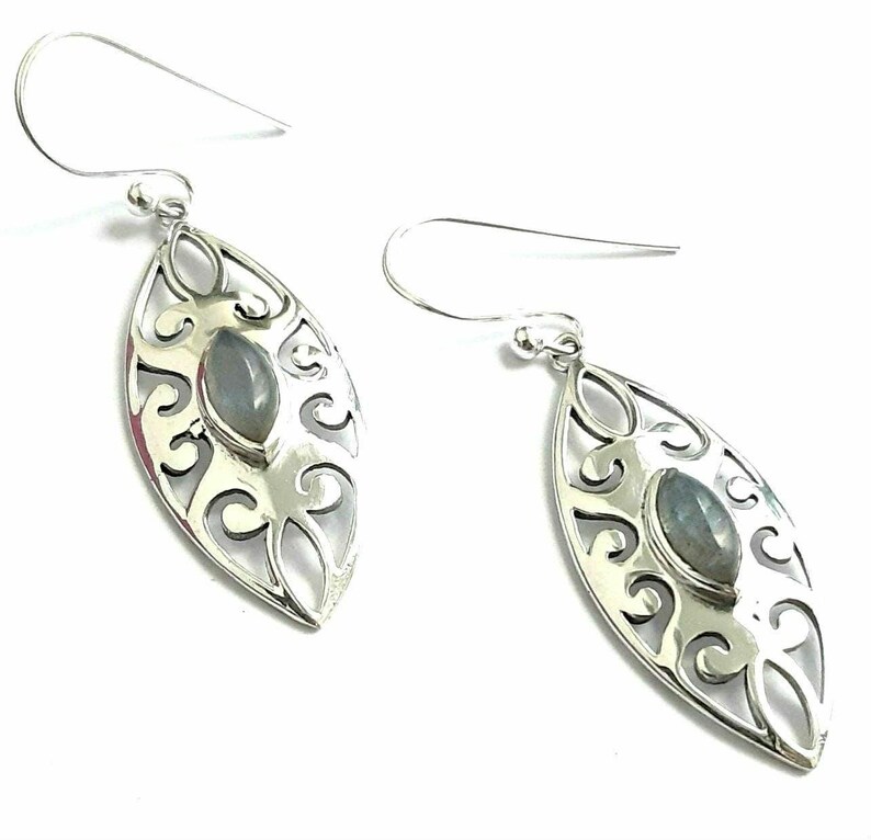 May include: Silver dangle earrings with a delicate filigree design and a gray gemstone in the center.
