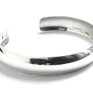 May include: A silver bangle bracelet with a smooth, polished finish.