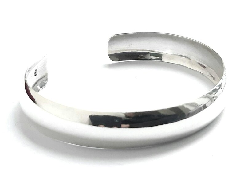 May include: A silver bangle bracelet with a smooth, polished finish.