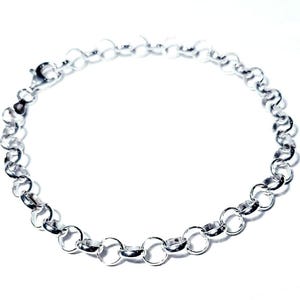 Puede incluir: Un brazalete de cadena de plata con cierre de mosquet&oacute;n. La cadena est&aacute; hecha de peque&ntilde;os eslabones redondos.