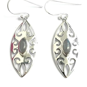 May include: A pair of silver earrings with a delicate filigree design and a gray gemstone in the center.