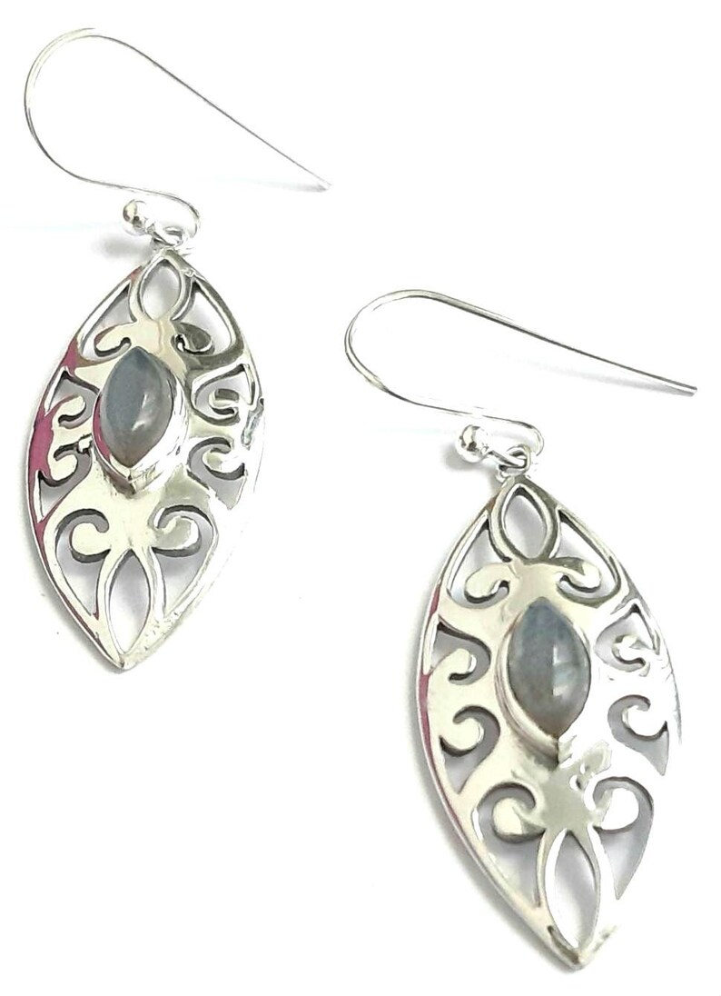 May include: Silver dangle earrings with a delicate, ornate design and a gray gemstone in the center.