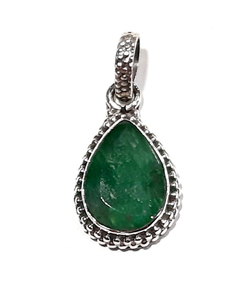 May include: A silver pendant with a teardrop-shaped green gemstone set in a beaded border.