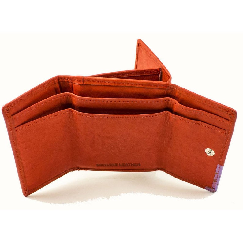 May include: An orange leather trifold wallet with three interior pockets and a snap closure. The wallet has the words "Genuine Leather" embossed on the front.