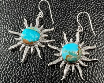 May include: A pair of silver earrings with turquoise stones set in a sunburst design.