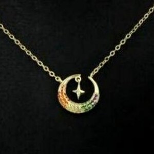 May include: A gold crescent moon necklace with a small star charm. The moon is decorated with colorful cubic zirconia stones.