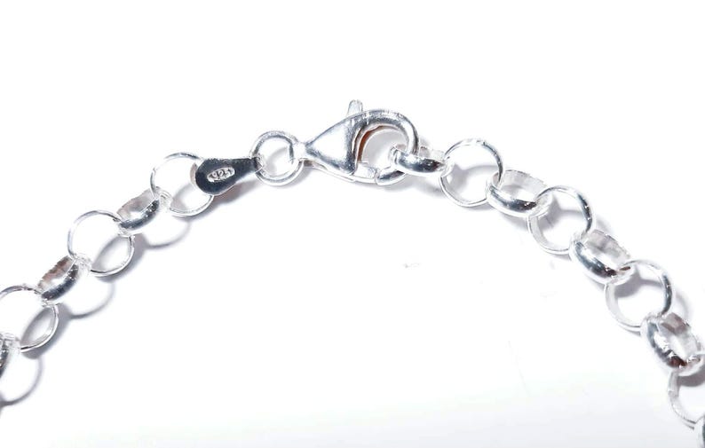 Puede incluir: Un brazalete de cadena de plata con cierre de mosquet&oacute;n. La cadena est&aacute; hecha de peque&ntilde;os eslabones redondos.