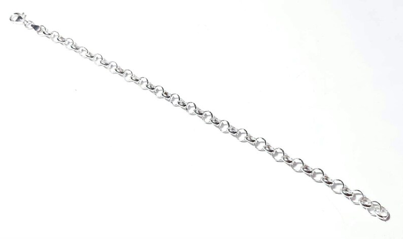 Puede incluir: Un brazalete de cadena de plata con cierre de langosta.