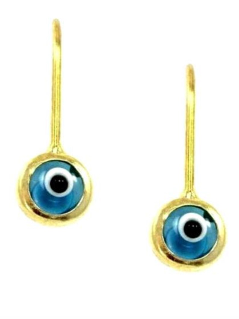 K&ouml;nnte beinhalten: Ein Paar goldene Ohrringe mit blauen b&ouml;sen Augen-Anh&auml;ngern. Die Anh&auml;nger sind rund und haben eine wei&szlig;e Pupille und eine schwarze Iris.