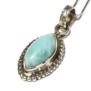 May include: A silver pendant necklace with a light blue oval-shaped gemstone set in a silver bezel. The pendant has a detailed silver border.