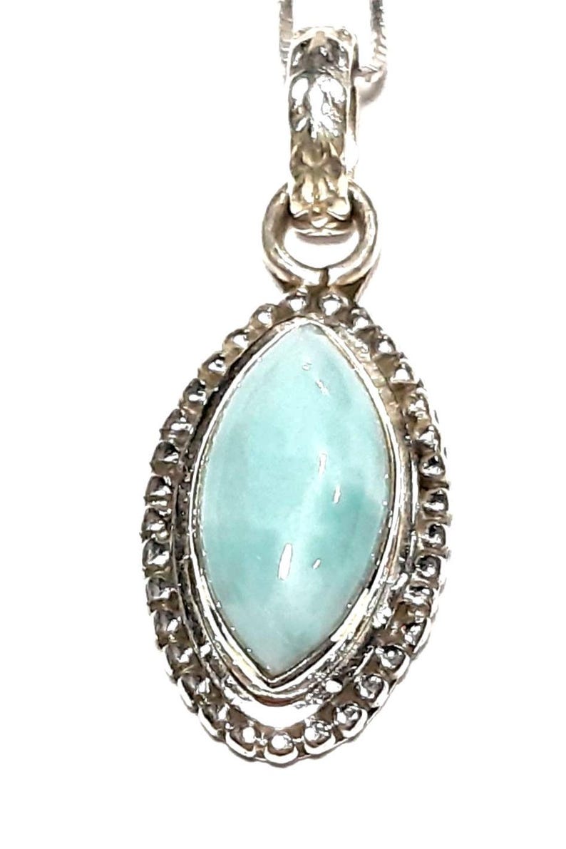May include: A silver pendant with a light blue marquise-shaped gemstone set in a beaded border.