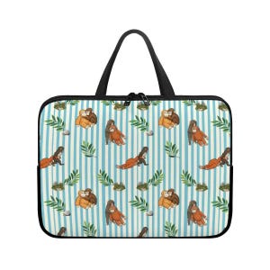 Może przedstawiać: Czarna torba na laptopa z powtarzającym się wzorem orangutanów, zielonych liści i małych kamieni na niebiesko-białym tle w paski. Torba ma czarny uchwyt i zamek błyskawiczny.