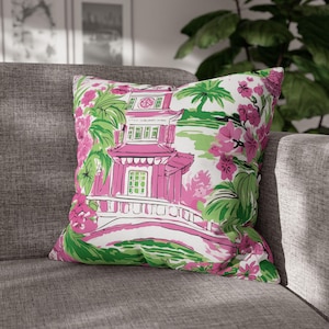 Könnte beinhalten: Ein rosa-grünes Kissen mit einem Blumenmuster und einem Pagoden-Design. Das Kissen hat einen weißen Hintergrund mit rosa Blumen, grünen Blättern und einer rosa Pagode mit einer Brücke.