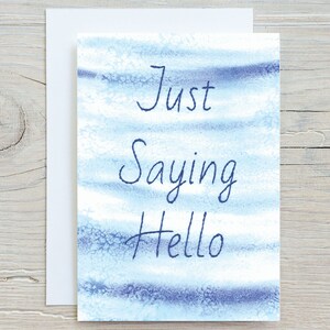 May include: A blue and white watercolour card with the text "Just Saying Hello" written in black ink.