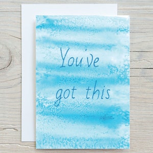 May include: A blue watercolour card with the text "You've got this" written in white.