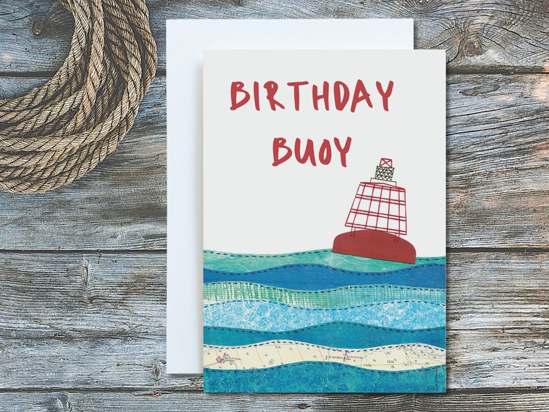 May include: A birthday card with a red and white buoy floating on blue and green waves. The card says "Birthday Buoy" in red lettering.