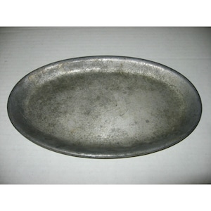 May include: A silver oval serving tray with a slightly textured surface.