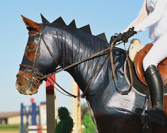 May include: A dark blue, glittery horse hood with a black mane-like fin along the top, covering the head and neck of a brown horse. The hood features a sleek, shimmering fabric and is worn under a brown leather bridle and saddle equipment.