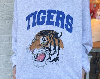 May include: A gray sweatshirt with a blue and white graphic of a tiger with the word "TIGERS" above it.