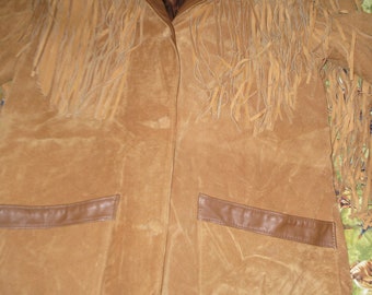 May include: A brown suede jacket with fringe detailing. The jacket has a brown leather collar and two pockets. The label on the jacket reads "Jackist Leatherwear".