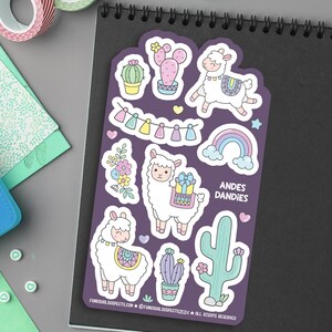 May include: A sheet of colorful stickers featuring cute llamas, cacti, rainbows, and hearts. The stickers are on a purple background and have the text "ANDES DANDIES" on them.