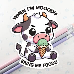 May include: A cartoon sticker of a black and white cow with big eyes holding a green and white ice cream cone. The sticker says "When I'm Moody Bring Me Foody".