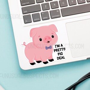 May include: A pink pig wearing a blue bow tie with the text "I'm a pretty pig deal" on a white laptop.