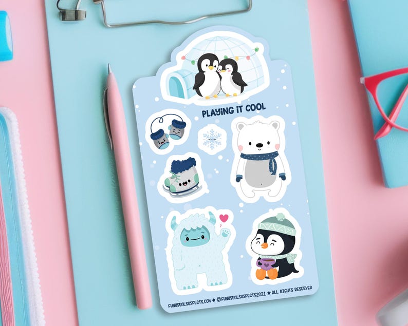 Puede incluir: Un conjunto de seis pegatinas de tem&aacute;tica invernal con un oso polar, ping&uuml;inos, un yeti y accesorios de invierno. Las pegatinas est&aacute;n sobre un fondo azul con el texto "Playing it Cool".